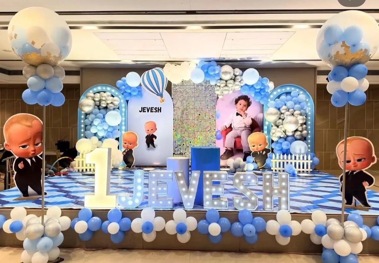 A boss themed decor for kids party with Baloon arch, neon light and cake table