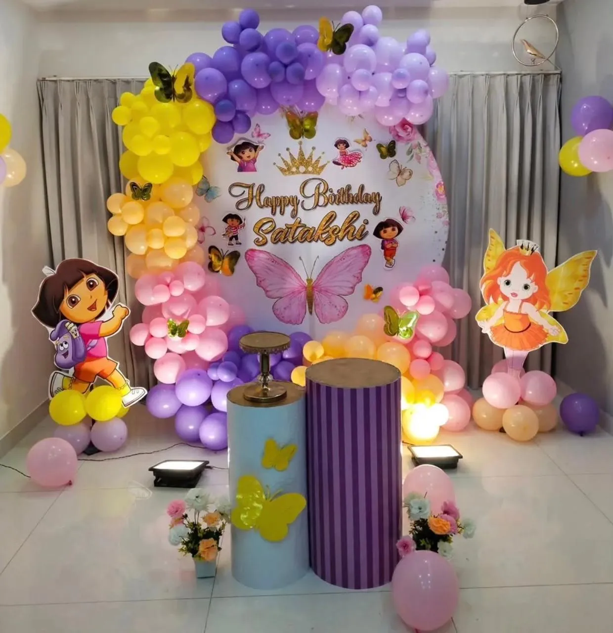 fairy and butterfly ring decor with balloons , 2 fairy cutouts,enhanced lights , 2 balloon pillars and cake stand.