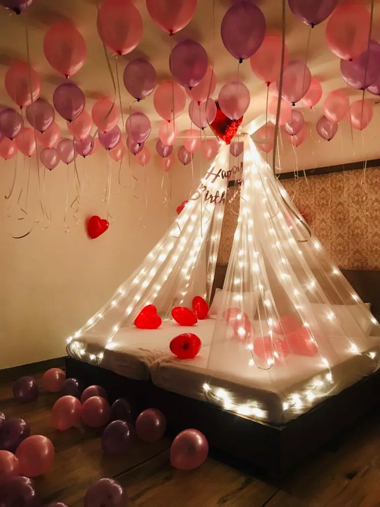 Romantic bedroom decoration with fairy lights and rose petals