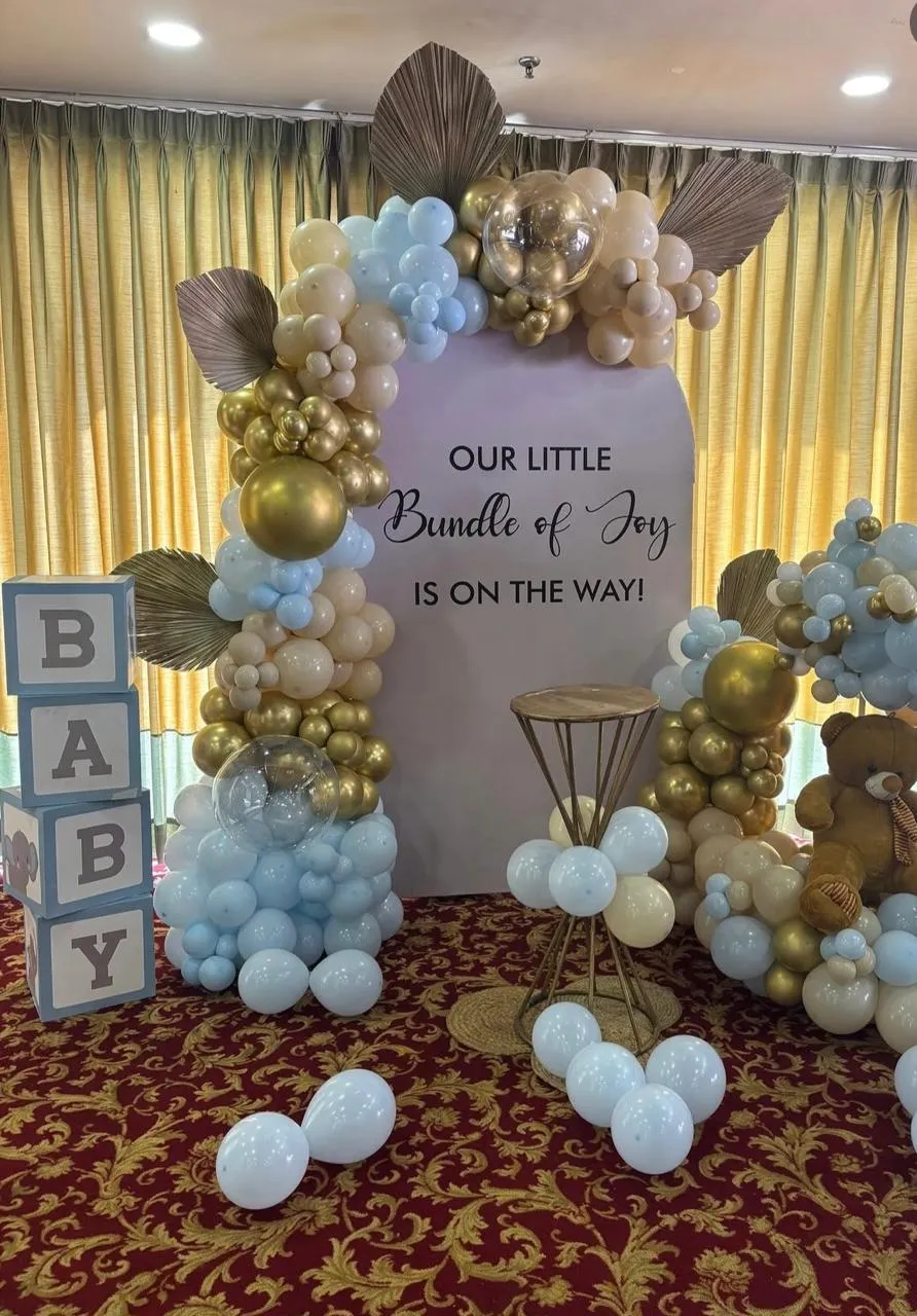 Baby Shower Decor with balloons, air balloons with teddy, cake table and artificial leafs.